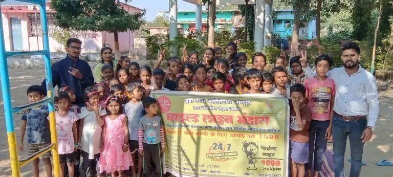 Group of children and adults next to a banner